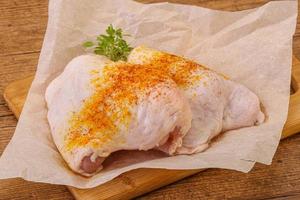 Raw chicken thigh with spices photo