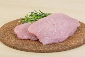 Turkey steak on wooden board and wooden background photo