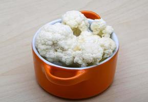 Cauliflower in a bowl on wooden background photo