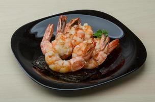 Tiger shrimps on the plate and wooden background photo