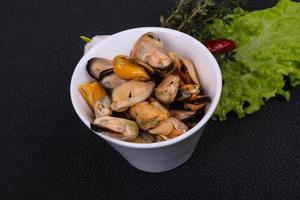 Pickled mussels in the bowl served pepper, garlic and salad photo