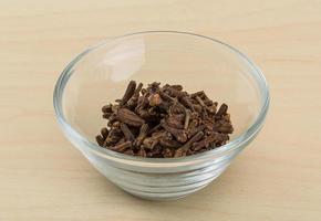 Clove seeds in a bowl on wooden background photo