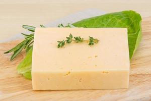 Yellow cheese on wooden board and wooden background photo