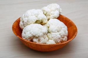 Cauliflower in a bowl on wooden background photo