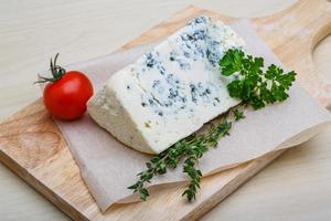 queso azul sobre tabla de madera y fondo de madera foto
