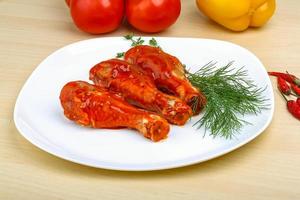 Chicken legs on the plate and wooden background photo