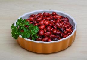 Canned beans in a bowl on wooden background photo