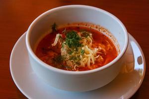 Tomato soup on wooden background photo