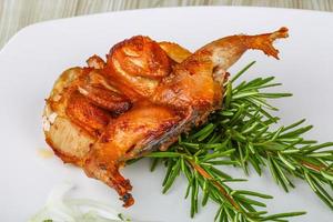 Grilled quail on the plate and wooden background photo