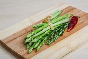 Raw asparagus on wooden board and wooden background photo