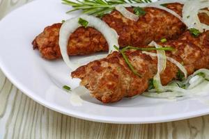 Beef kebab on the plate and wooden background photo