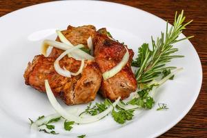 Shashlik on the plate and wooden background photo