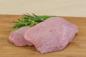 Turkey steak on wooden board and wooden background photo