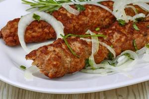 Beef kebab on the plate and wooden background photo