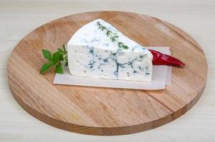 Blue cheese on wooden board and wooden background photo