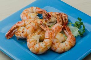 Tiger shrimps on the plate and wooden background photo