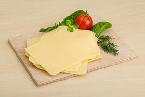 Sliced sheese on wooden board and wooden background photo