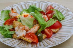 Caesar salad on the plate and wooden background photo