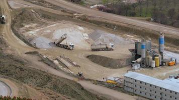 Las máquinas de construcción de 8k en el centro de producción de hormigón están trabajando en el sitio de construcción video