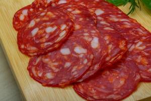 Chorizo sausage on wooden board and wooden background photo