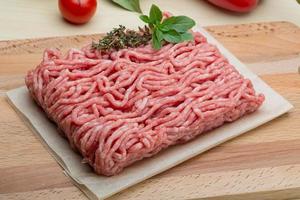 Minced meat on wooden board and wooden background photo