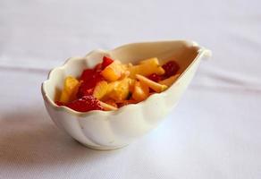 Fruit salad in a bowl on white background photo