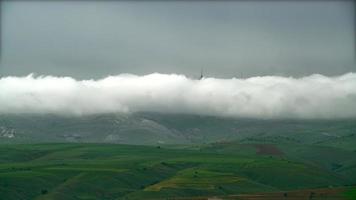 8K White long stripe clouds disperse over green fields video