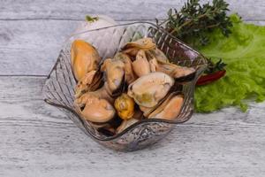 Pickled mussels in the bowl served pepper, garlic and salad photo