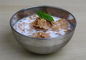 Cornflakes in a bowl on wooden background photo