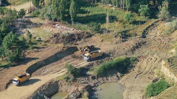 La pelle 8k remplit la terre dans le camion de terrassement video