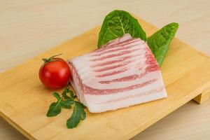 Bacon on wooden board and wooden background photo