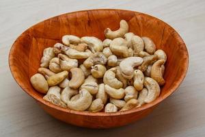 Cashew nuts in a bowl on wooden background photo