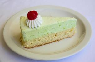 Pistachio cheesecake on the plate and white background photo