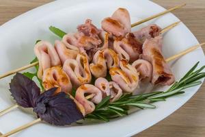 Grilled squid on the plate and wooden background photo