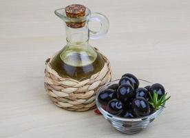 Olive oil on wooden background photo