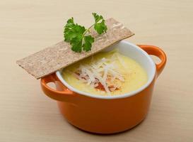 Cheese soup in a bowl on wooden background photo