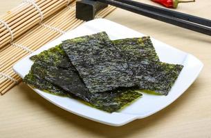 Nori sheets on the plate and wooden background photo