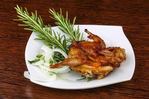 Grilled quail on the plate and wooden background photo