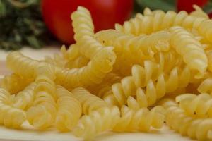 Raw rotini on wooden background photo