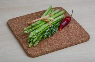 Raw asparagus on wooden board and wooden background photo