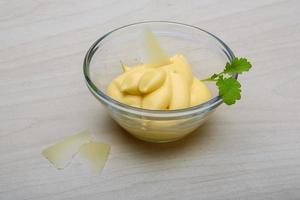 Cheese sauce in a bowl on wooden background photo