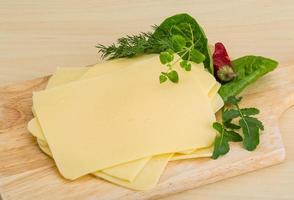 Sliced sheese on wooden board and wooden background photo