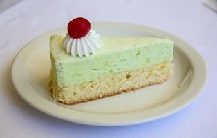 Pistachio cheesecake on the plate and white background photo