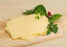 Sliced sheese on wooden board and wooden background photo