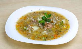 sopa de cereales en el plato y fondo de madera foto