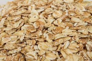 Heap of dry rolled oats isolated on white background photo