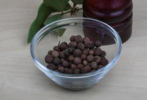 Pepper mill on wooden background photo