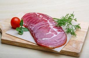 Sliced Ham on wooden plate and white background photo