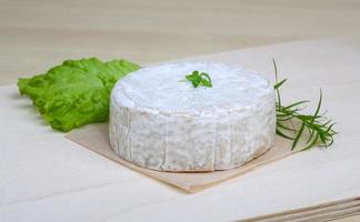 Camembert cheese on wooden board and wooden background photo