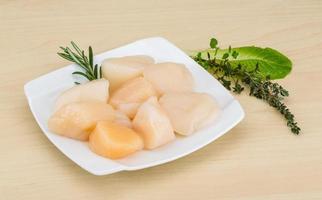 Raw scallops on the plate and wooden background photo